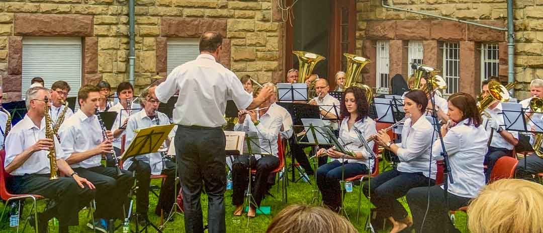 Die Stadtkapelle Heppenheim spielt im Klostergarten | Orchester mit Dirigent davor